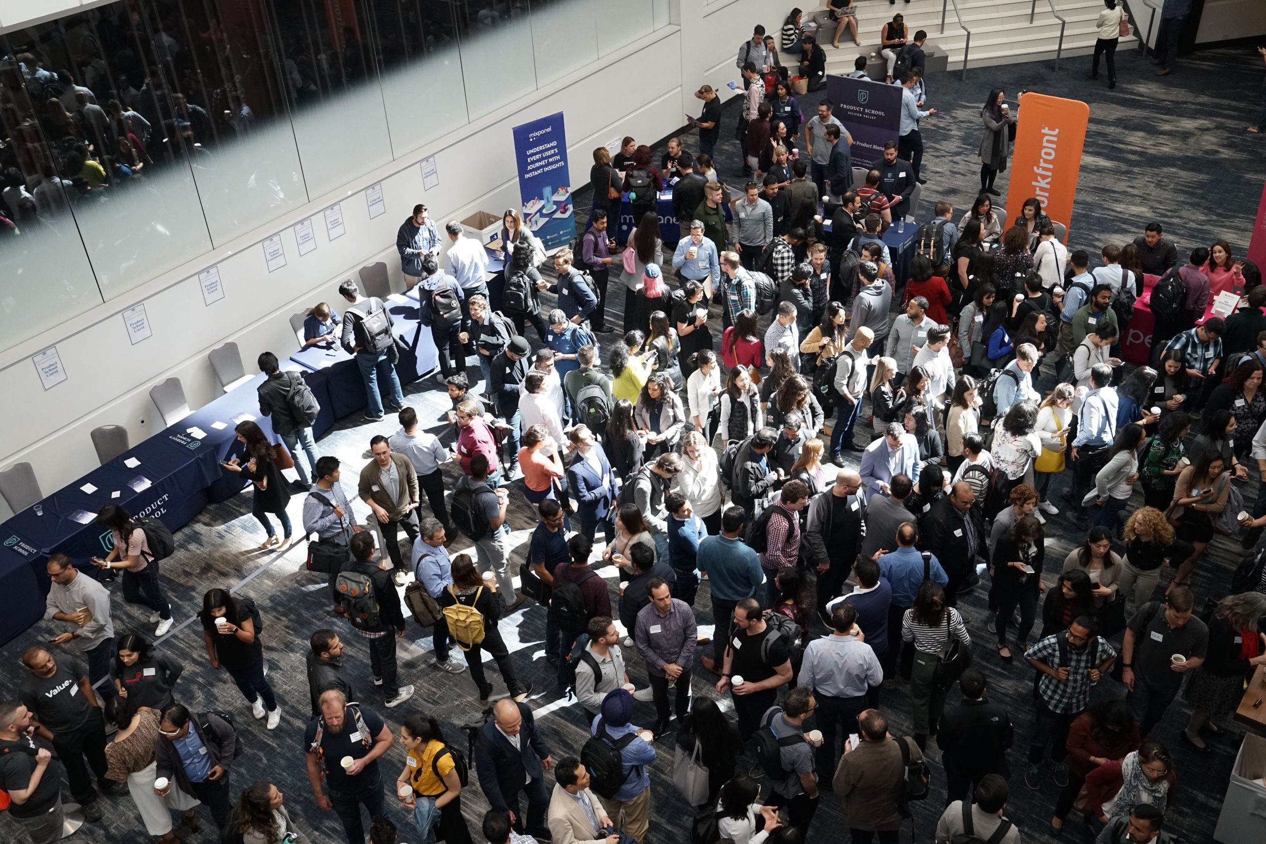 Visitantes registrándose en la entrada de una feria de eventos, destacando la importancia de la organización y acogida en eventos.